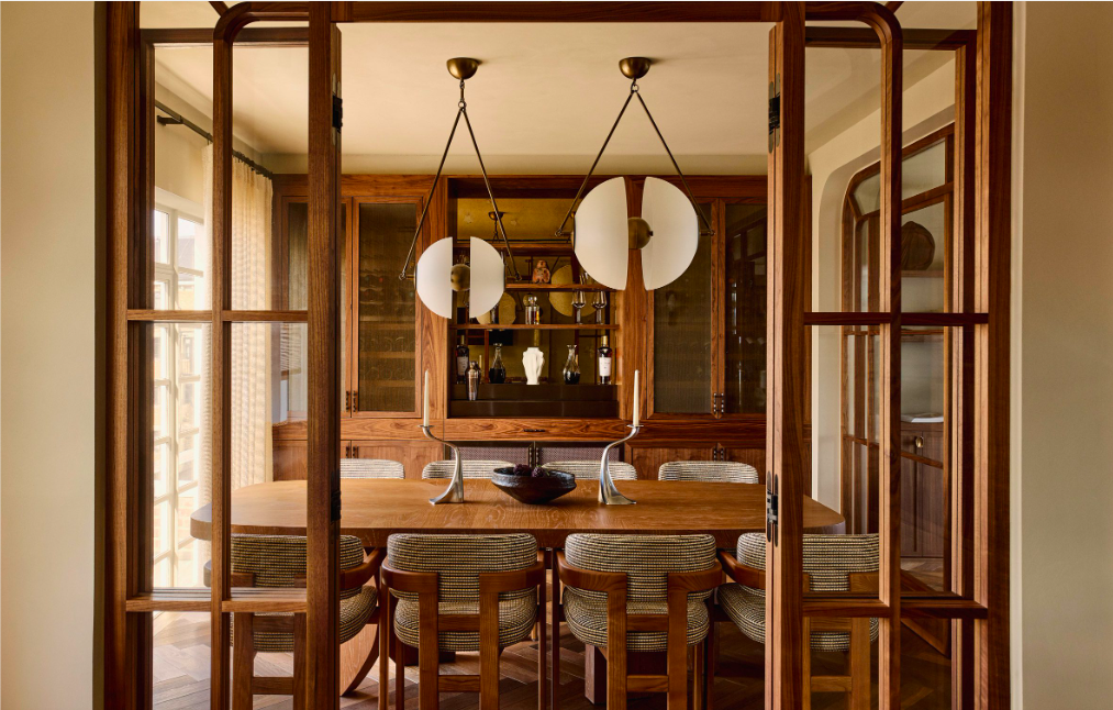 Salle à manger en bois avec table rectangulaire, chaises tapissées et suspensions design